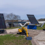 2 Creacar 20ft mobile solar panel containers at a construction site - opened for power collection